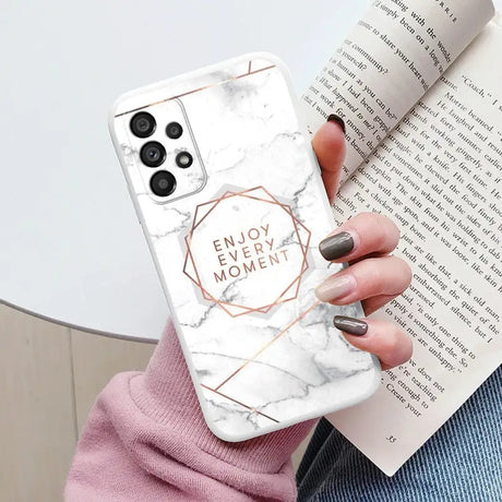 a woman holding a white marble phone case with the words enjoy moment