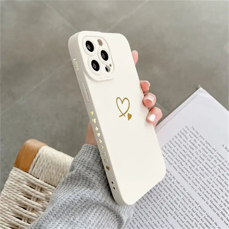 A woman holding a white phone case with a heart