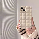 a woman holding up a white phone case