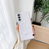 a woman holding a white phone case with a white flower design