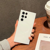 a woman holding a white phone with a coffee cup