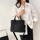 a woman wearing a white shirt and black pants holding a black bag