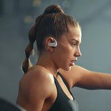 Woman wearing wireless earbuds and a black athletic top.