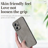 the back of a woman’s hand holding a gray iphone case