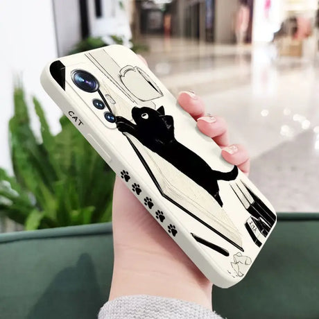 a woman holding a phone case with a black cat on it