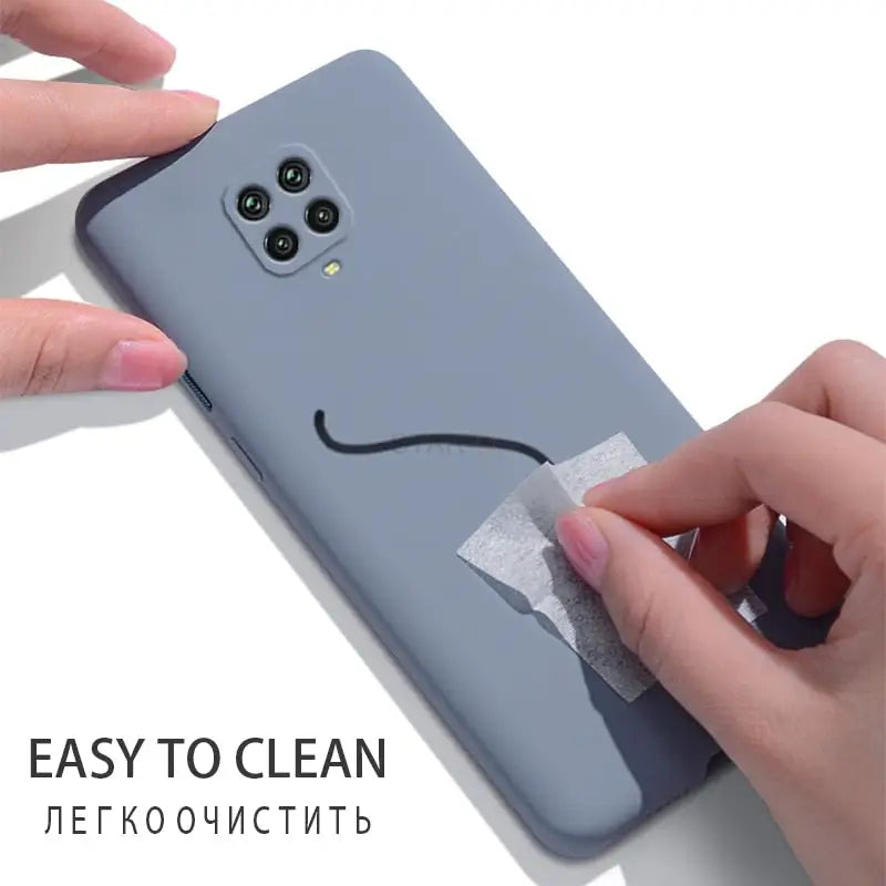 a woman is putting a piece of tape to the back of her phone