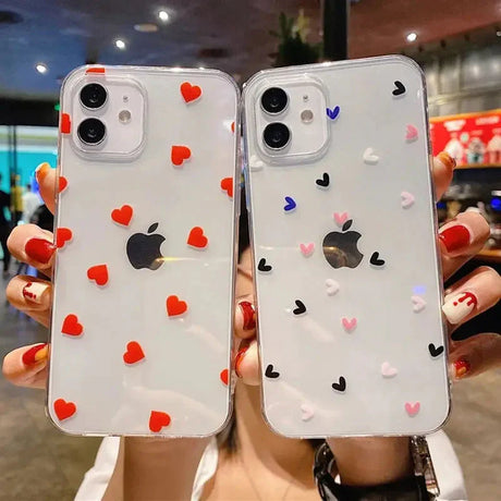 two women holding up their iphone cases with hearts on them