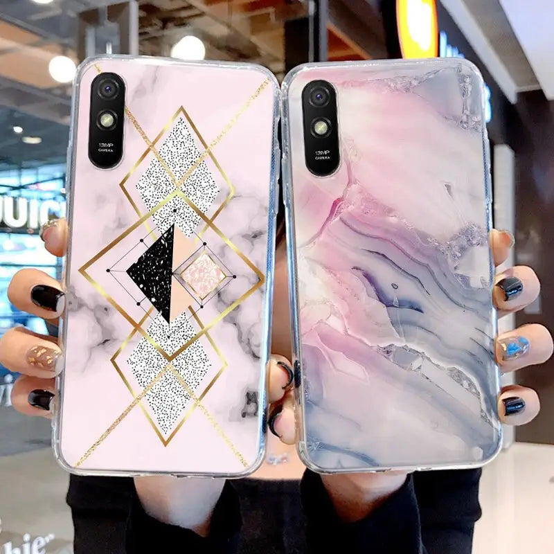 a woman holding two marble phone cases
