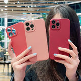 a woman holding two red iphone cases