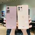 two women holding up their iphones with heart shaped cases