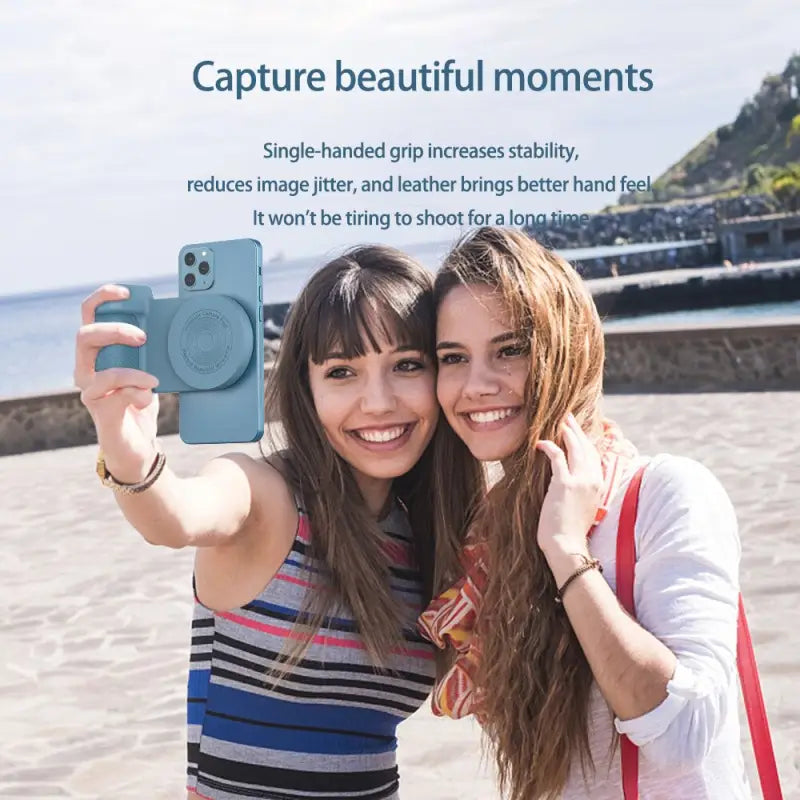 two women taking a selfie on the beach with a camera