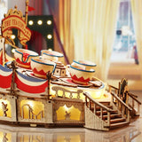 a wooden toy boat with a christmas tree in the background