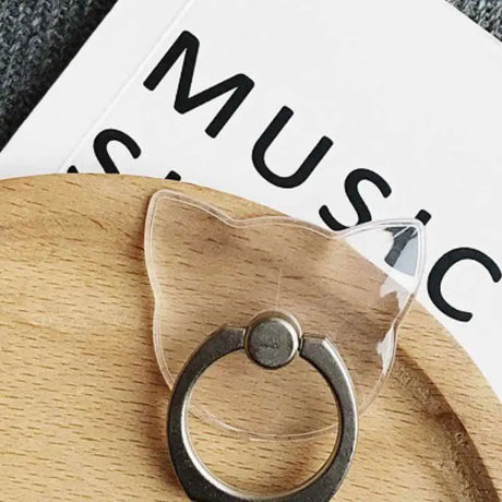 a cat shaped ring on top of a wooden plate