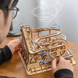 a person is working on a wooden model