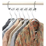 a white rail with four shirts hanging on it