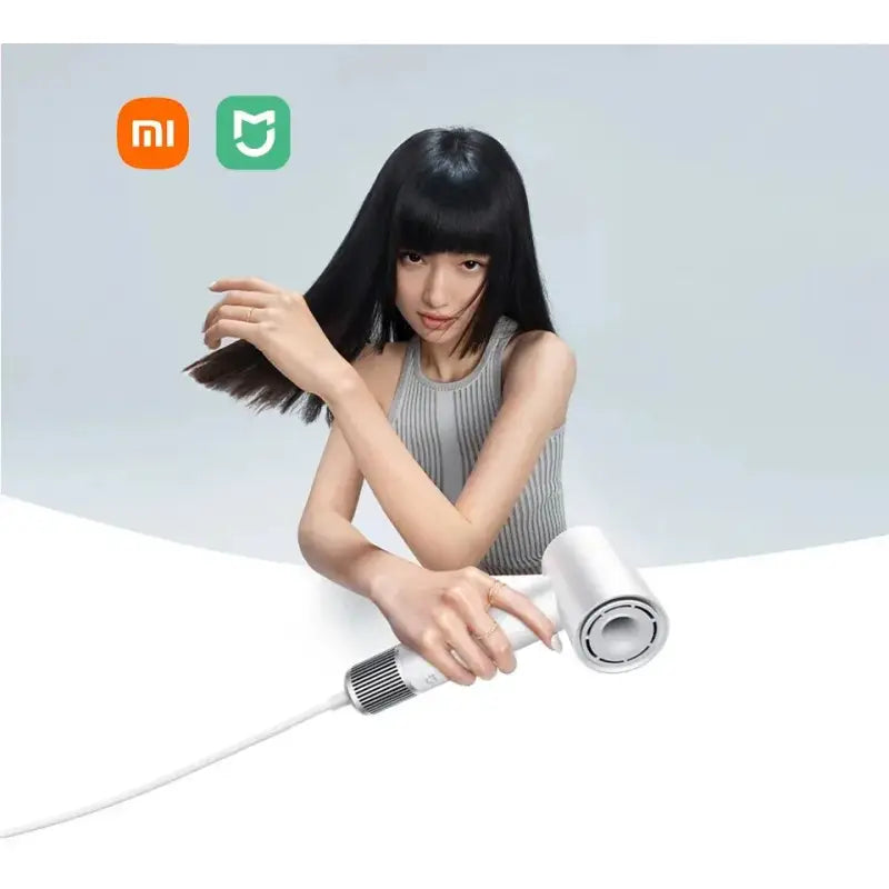 a woman is using a hair dryer