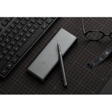 a close up of a keyboard, pen, glasses and a cell phone