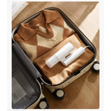 a piece of luggage with a blanket and toilet paper