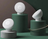 three white lights on a green pedestal with a green background