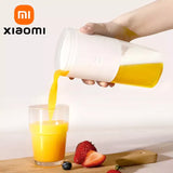 a person pouring orange juice into a glass