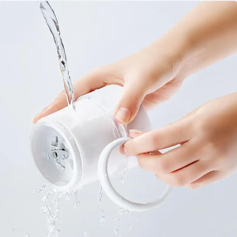 a person pouring water from a white cup