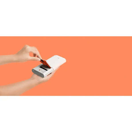 a hand holding a credit card in front of an orange background