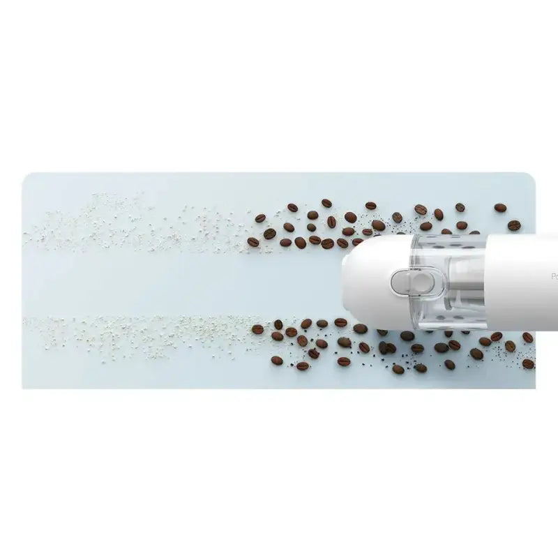 a white coffee grinder with coffee beans scattered on it