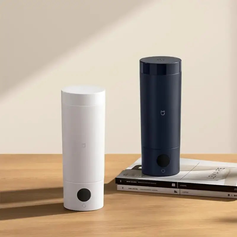 a white and black smart speaker sitting on top of a wooden table