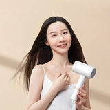 a woman holding a white hair dryer