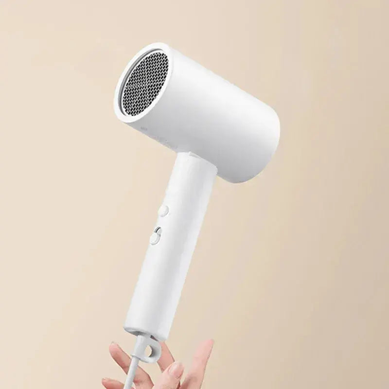 a woman holding a hair dryer in her hand