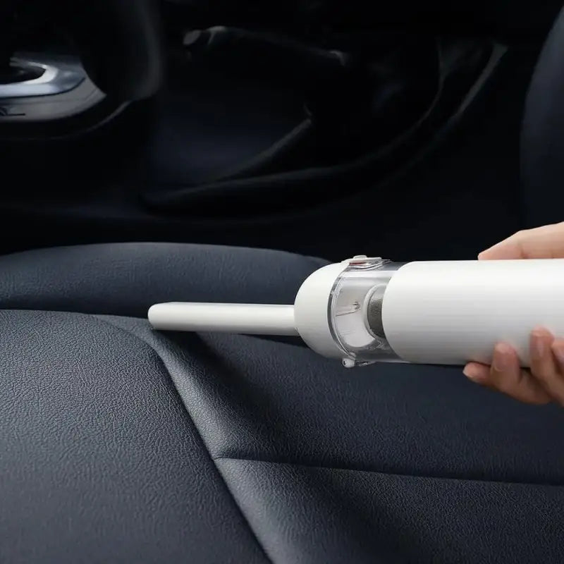 a person using a car air freshener to clean the interior