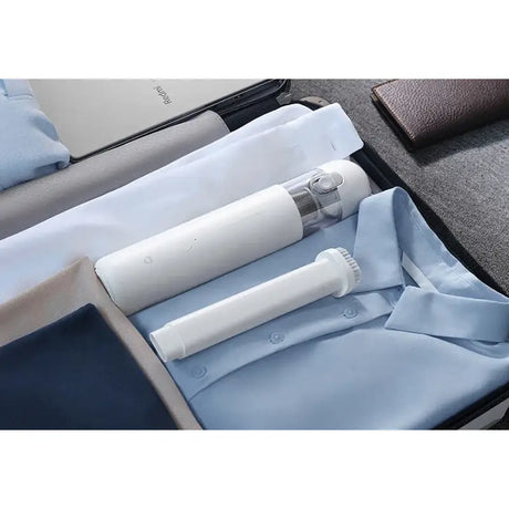 a white and blue suitcase with a roll of toilet paper