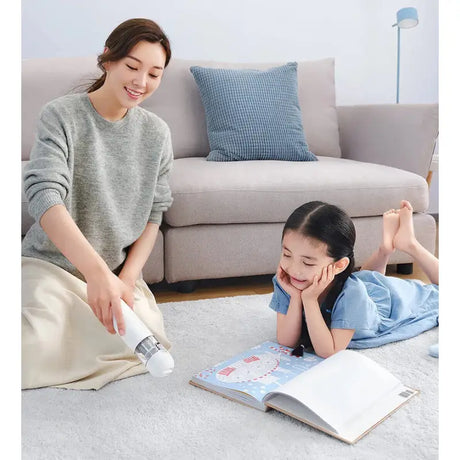 a woman and child laying on the floor reading a book