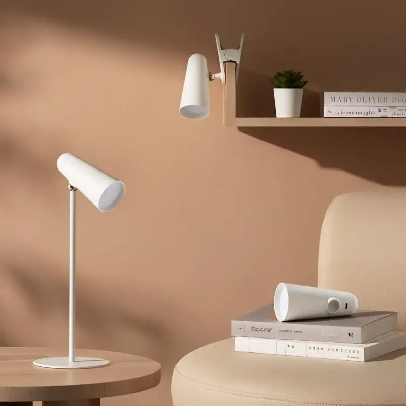 a white lamp on a table next to a chair