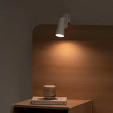 a lamp on a table next to a book