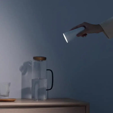 a woman is pouring water into a glass pitcher