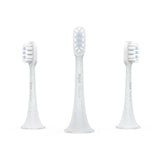 three white toothbrushs with a white background