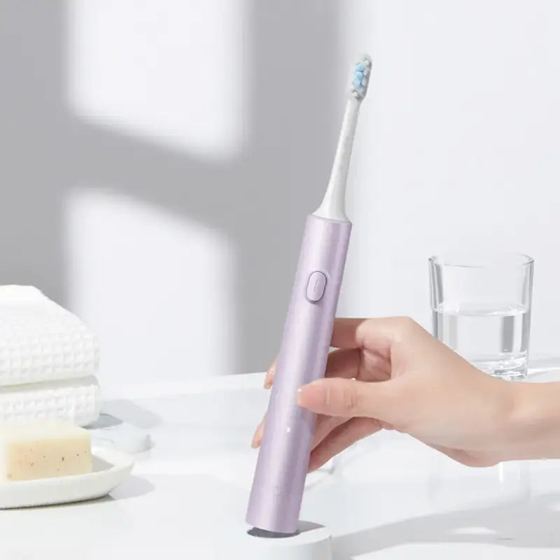 a woman is using a toothbrush to clean her teeth