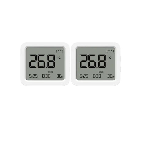 two white digital clocks are displayed on a white surface