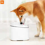 a dog drinking water from a water fountain