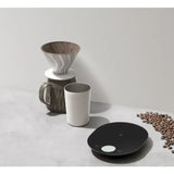 a coffee grinder and a cup on a table
