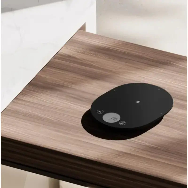 a black google home hub on a wooden table