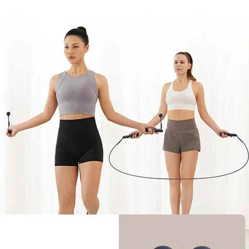 two women in sports wear are using a jump rope