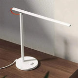 a white desk lamp on a wooden table