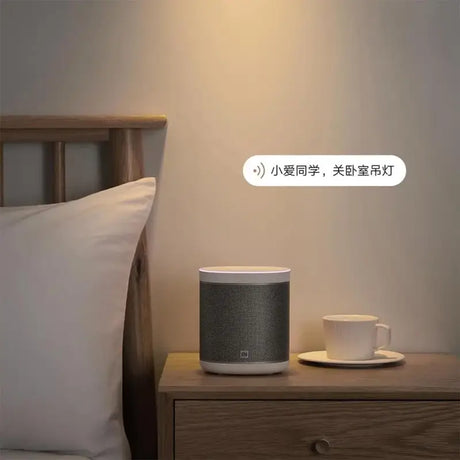 a white smart speaker sitting on top of a bed