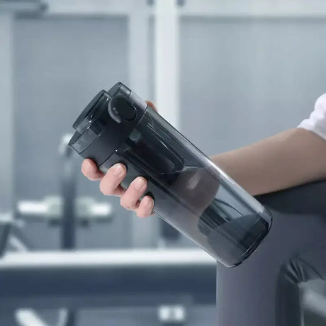 a man is sitting on a bench holding a water bottle