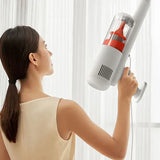 a woman is holding a vacuum cleaner