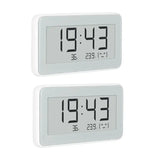 two white digital clocks with thermometers