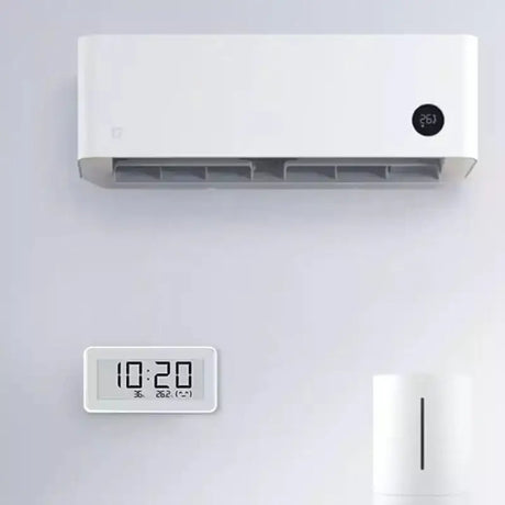 a close up of a clock and a air conditioner on a wall