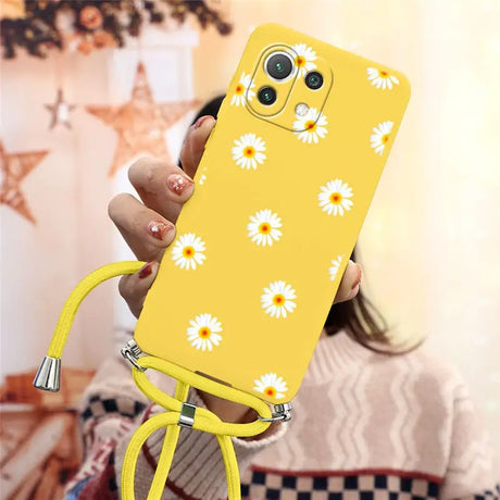 there is a woman holding a yellow phone case with daisies on it